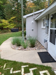 Kitchen entrance (to the right) / Wood pile (way back near the tree line)